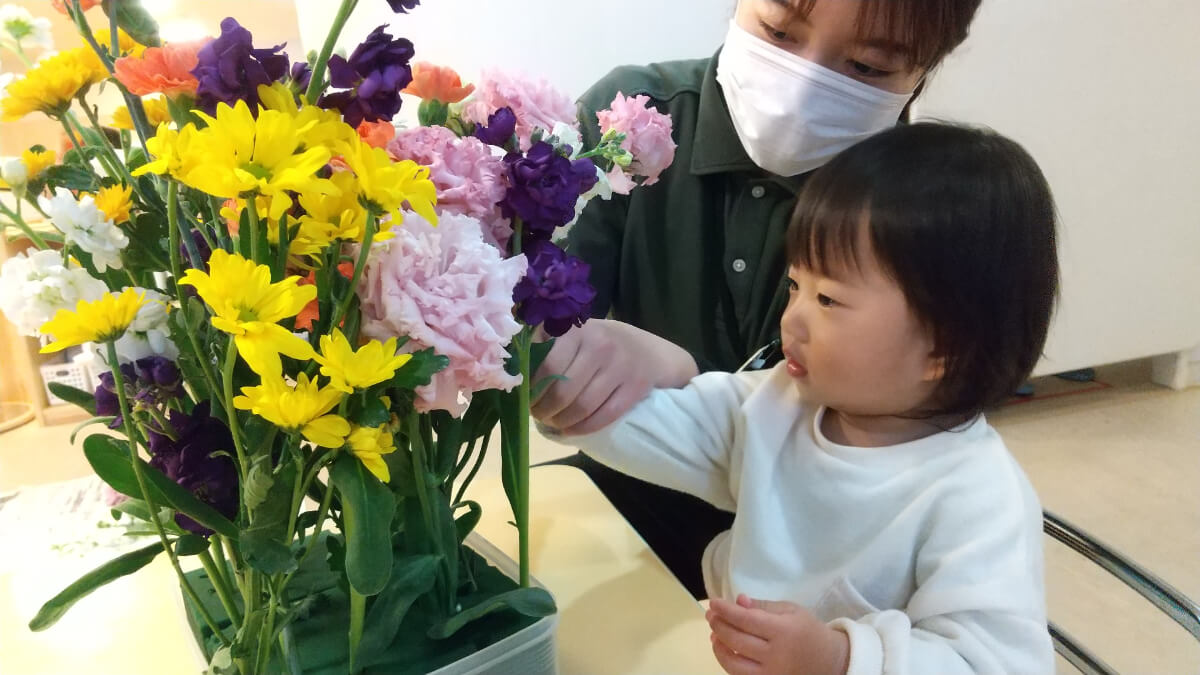 給水スポンジに花をさす子ども