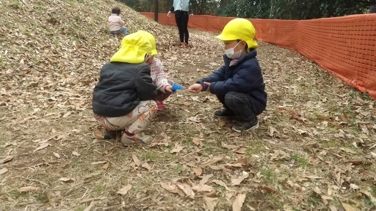 落ち葉で遊ぶ子どもたち