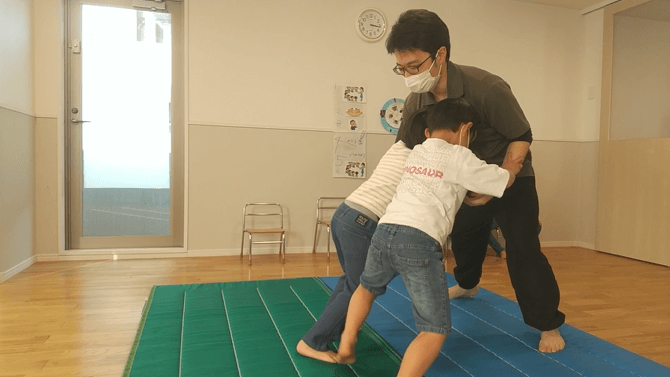 相撲をする子どもとスタッフ