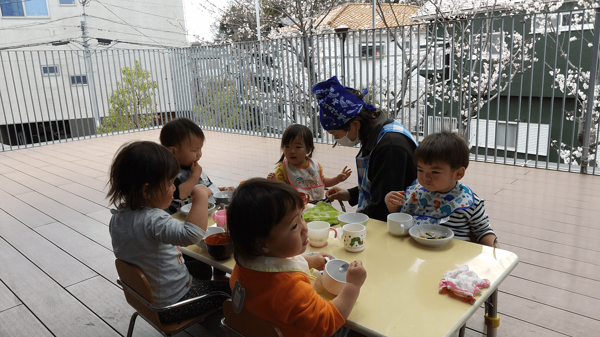 テラスで給食を食べる子どもたち