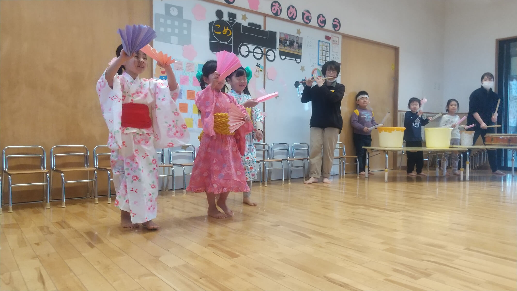 自分たちで作った扇子を持って踊る子どもたち