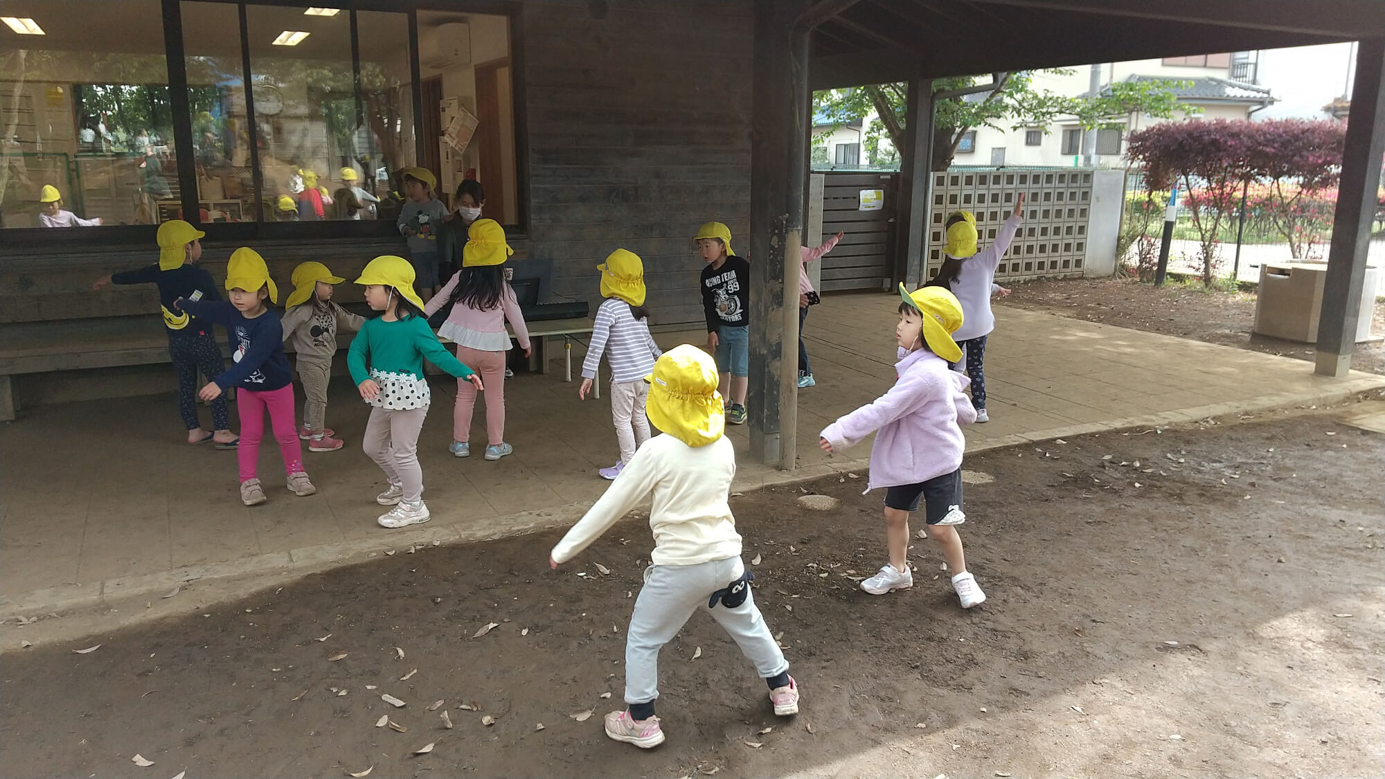 園庭でさくらさくらんぼリズムをする子どもたち