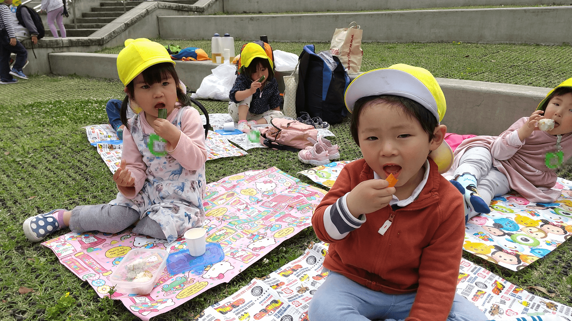 レジャーシートを敷いてお弁当を食べる子どもたち