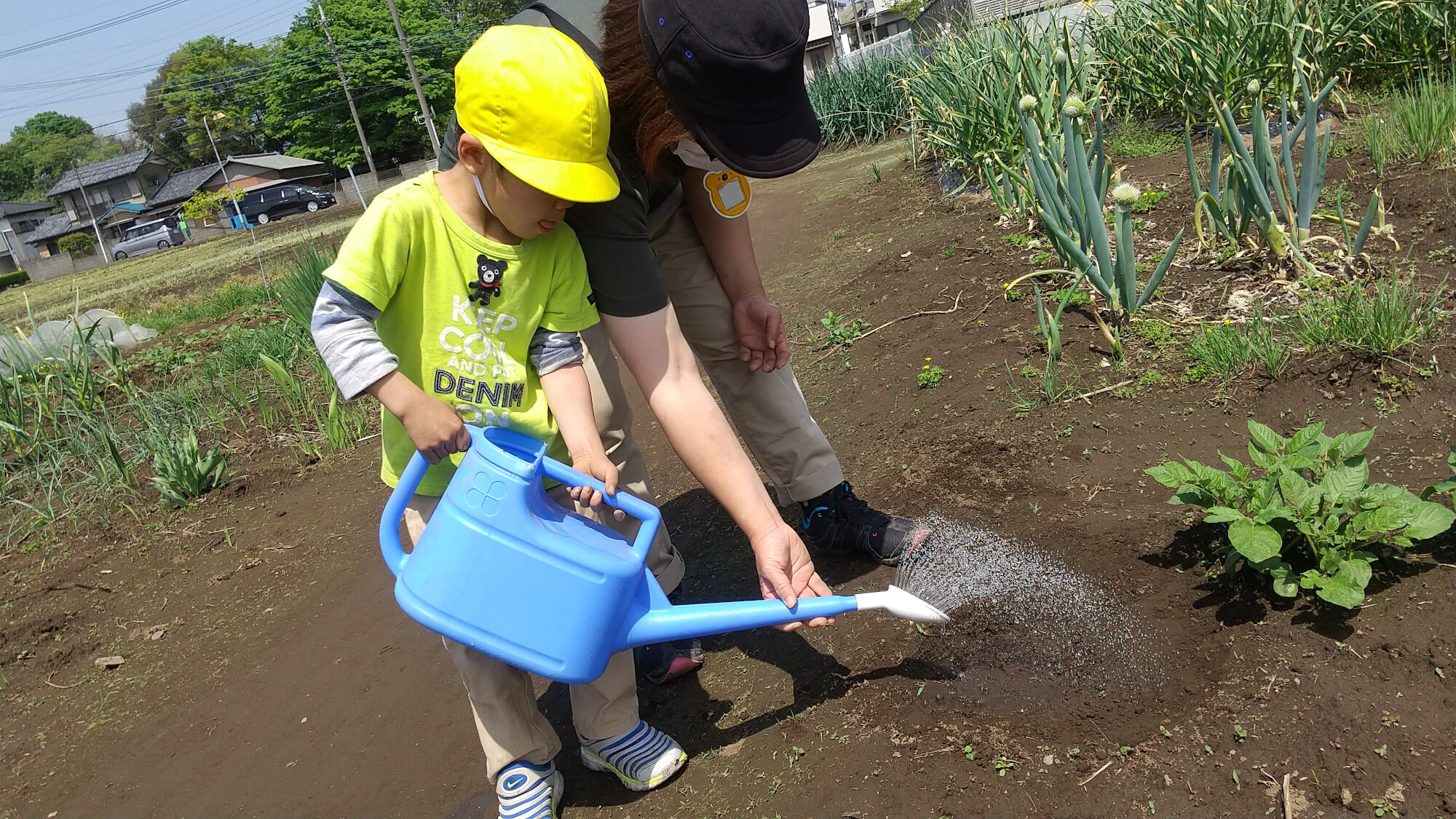 じょうろで水をまく子ども