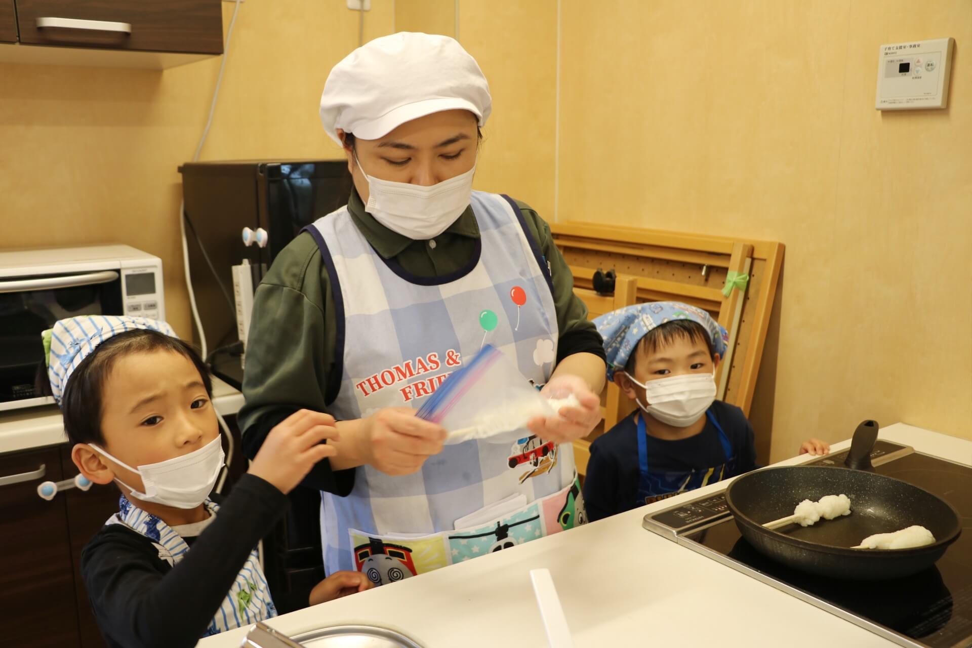 子どもたちと五平餅を焼く新井さん