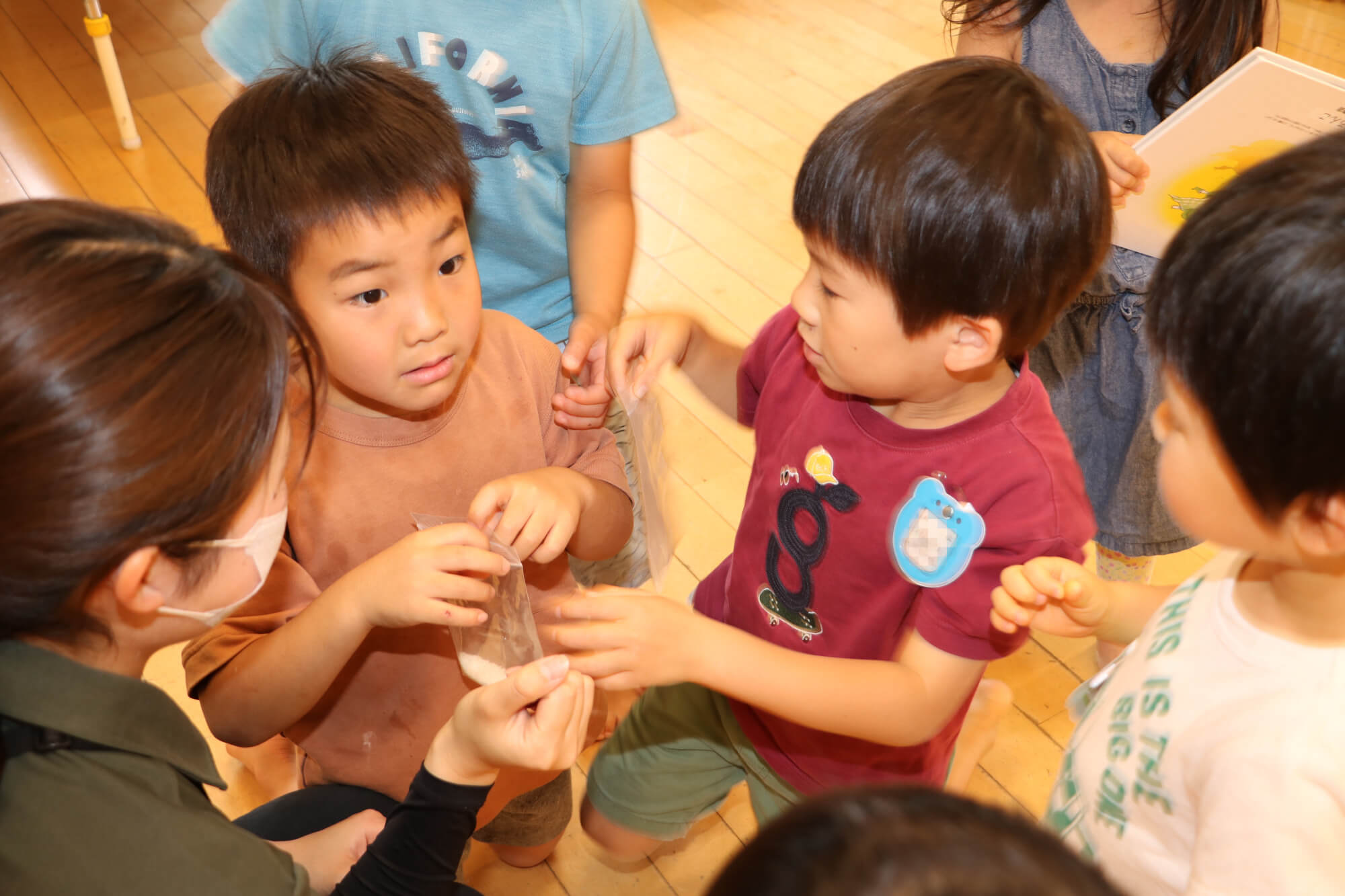 子どもたちと一緒に米のにおいを感じ取る岡本さん