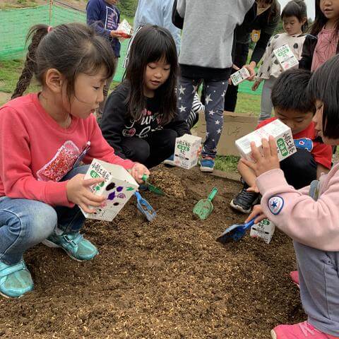 土を入れる子どもたち