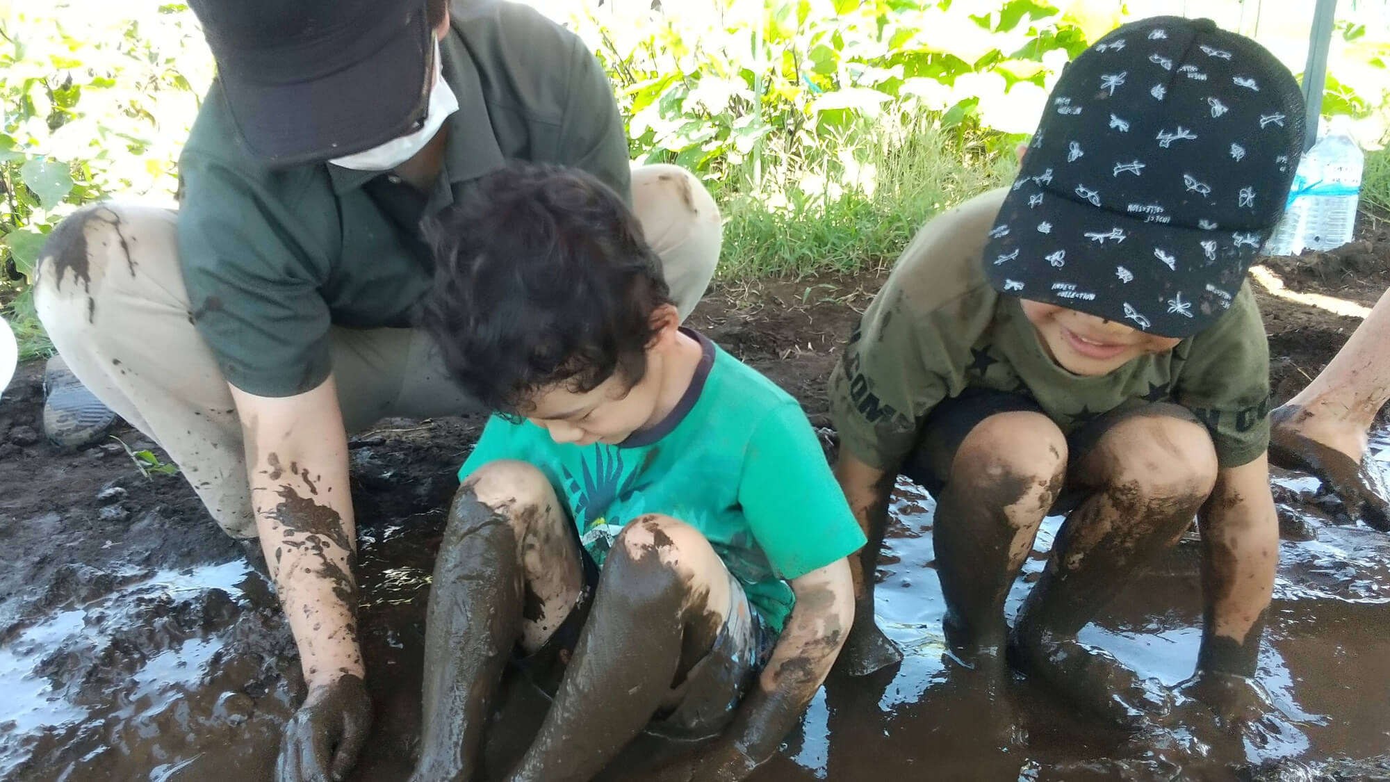 泥の上に座る子どもたち