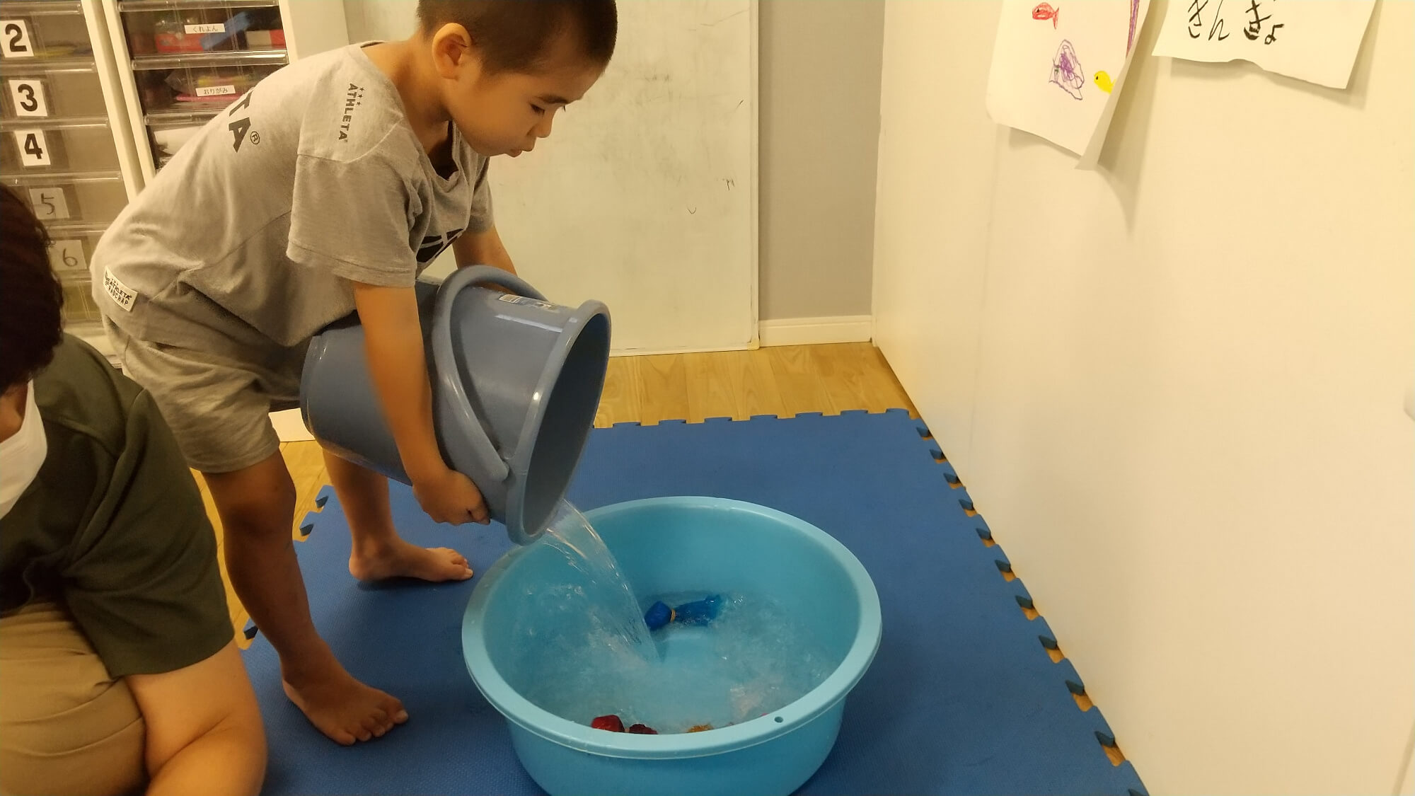 金魚すくいの準備をする子ども