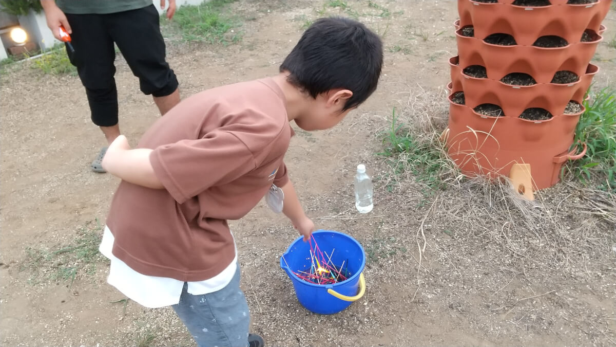 花火を水のバケツへ