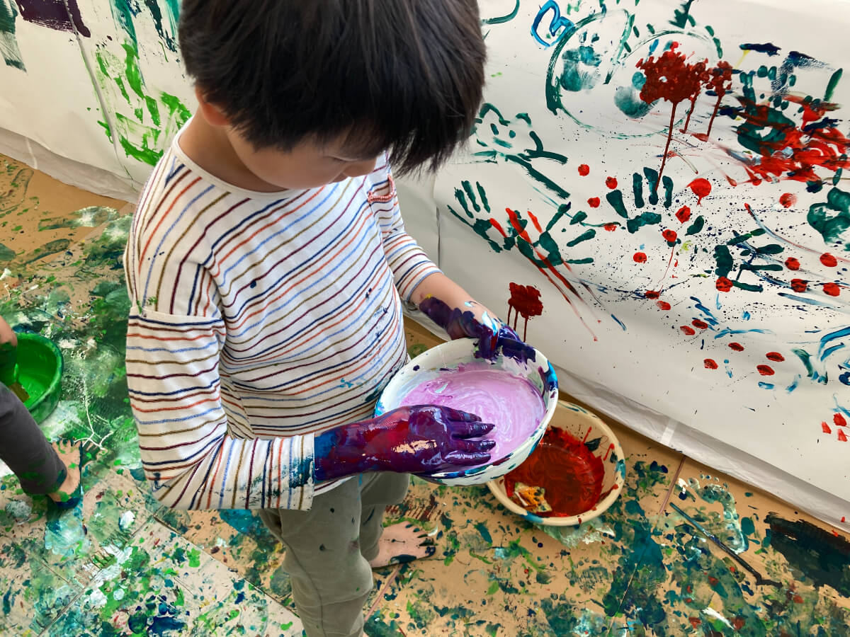 手で絵の具を混ぜる子ども