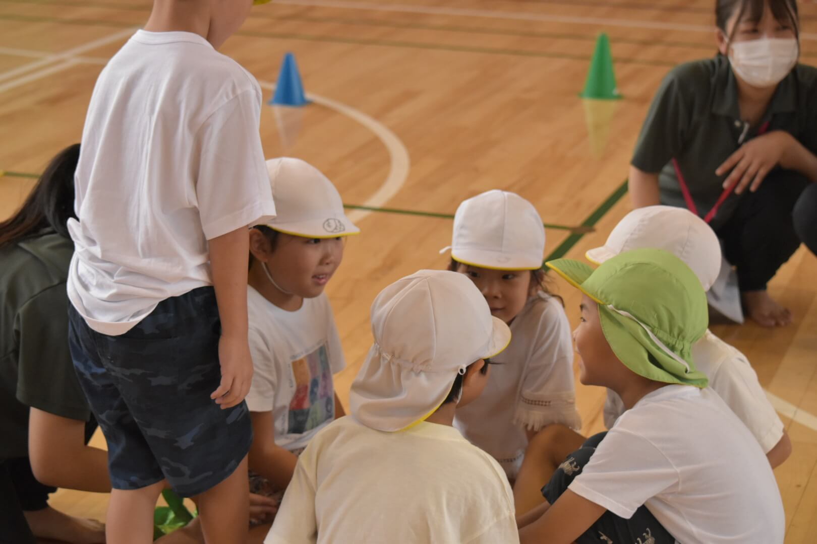 リレーでどうしたら勝てるか相談する子どもたち