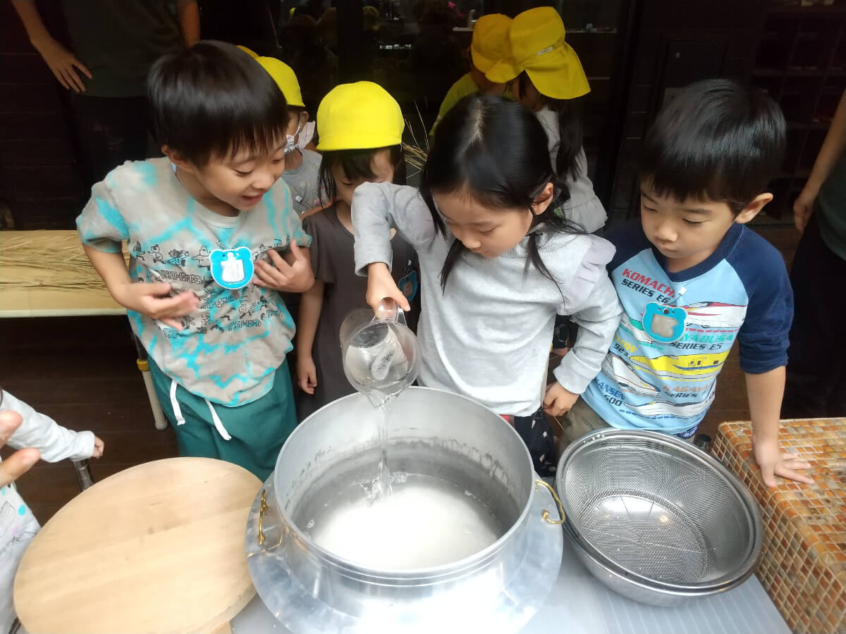 釜に水をいれる子どもたち