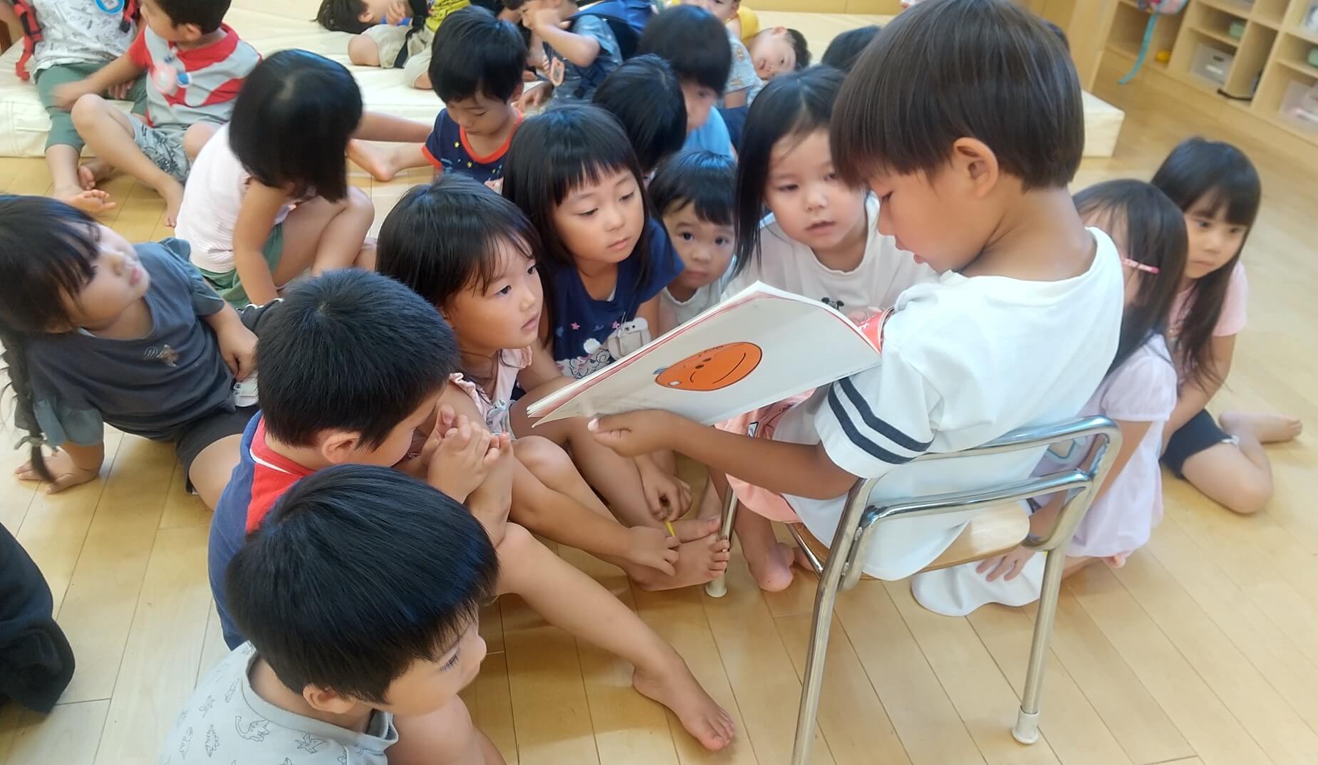 年上の子が年下の子に読み聞かせ