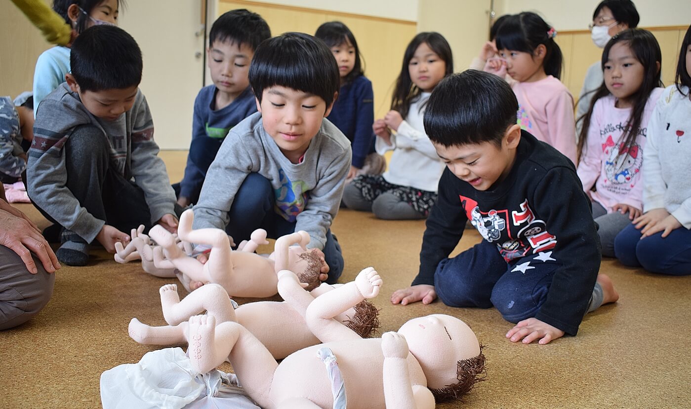 胎児人形を使い、お腹の中で赤ちゃんが育つ様子を知る子どもたち