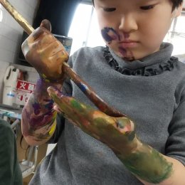 腕まで絵の具を塗っている子ども