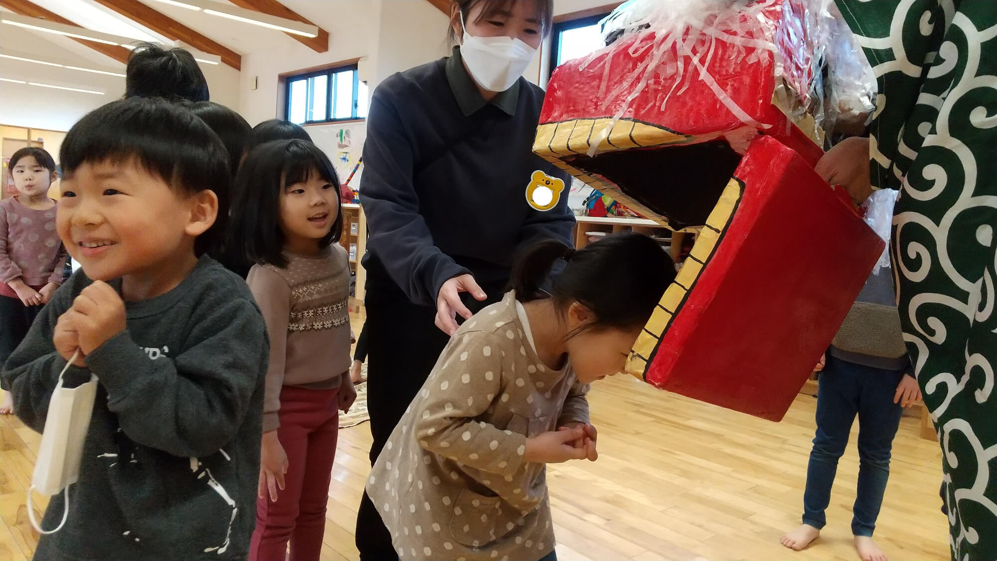 獅子舞に頭をかまれる子どもたち