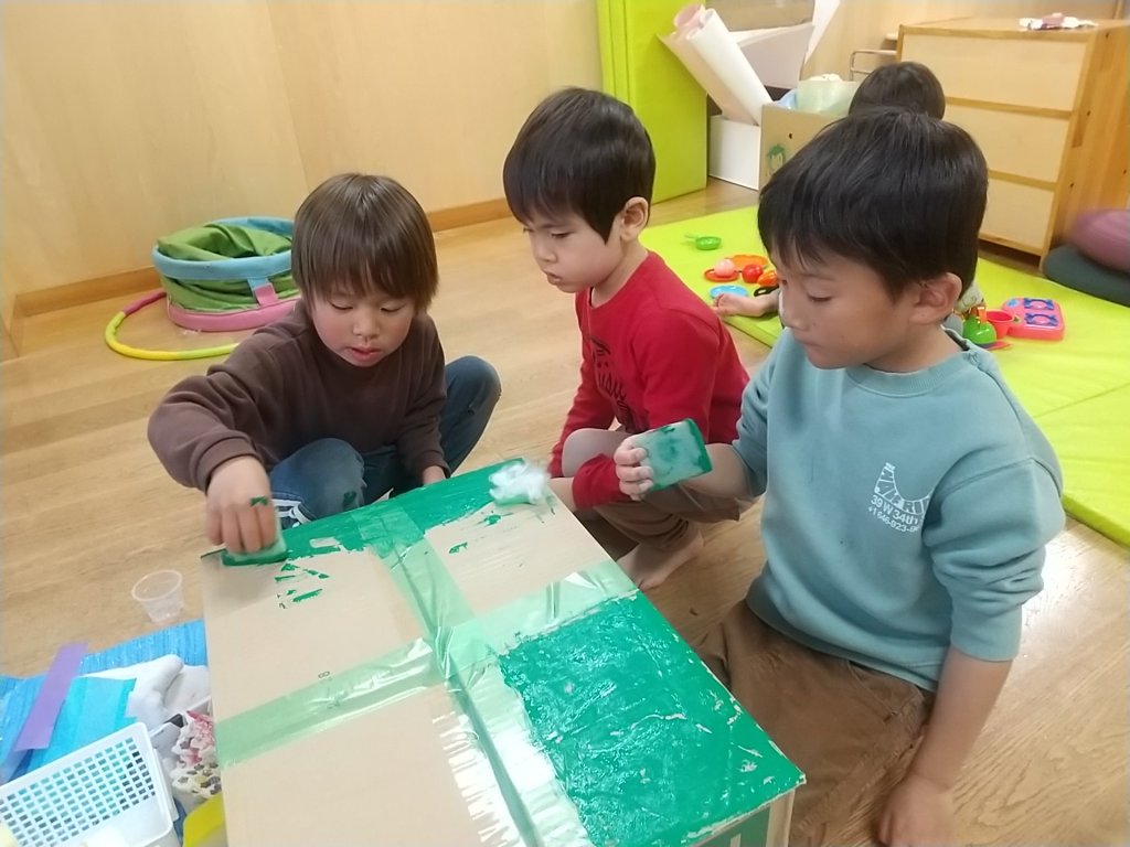 段ボールに色をぬる子どもたち