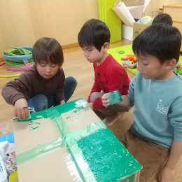 段ボールに色をぬる子どもたち