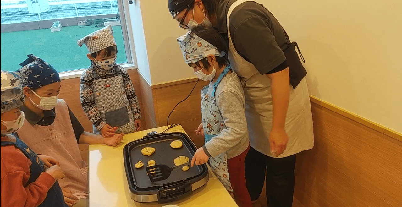 ホットプレートでサツマイモ焼く子どもたち