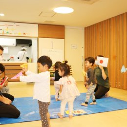 日本とカナダの国旗の間を紙飛行機を飛ばして遊ぶ