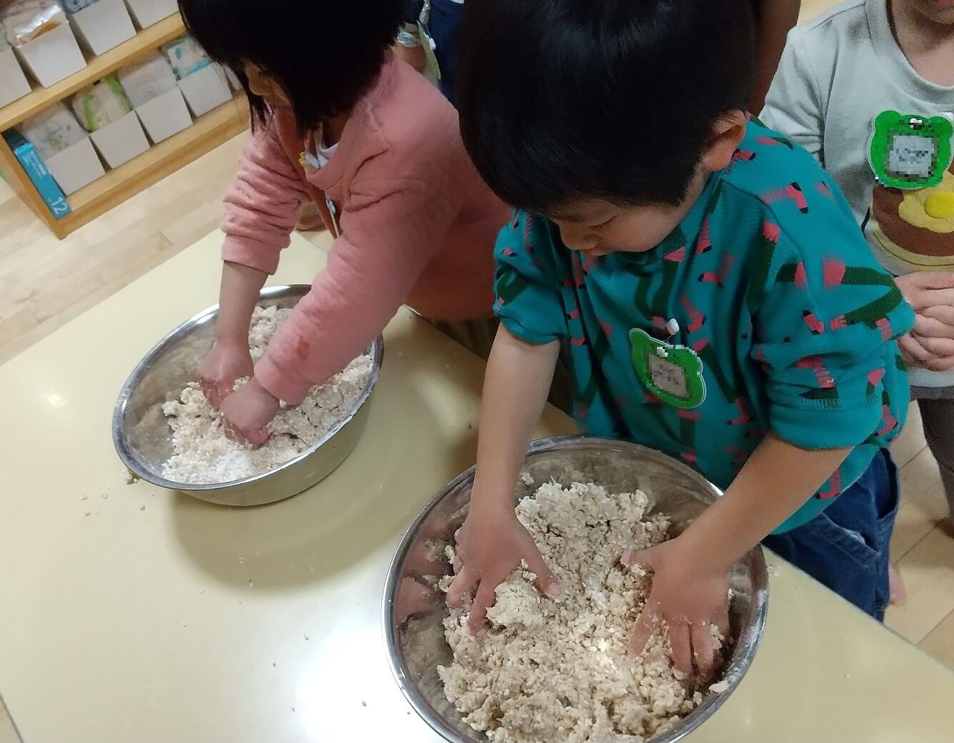 つぶした大豆と麹・塩を混ぜてこねる子どもたち