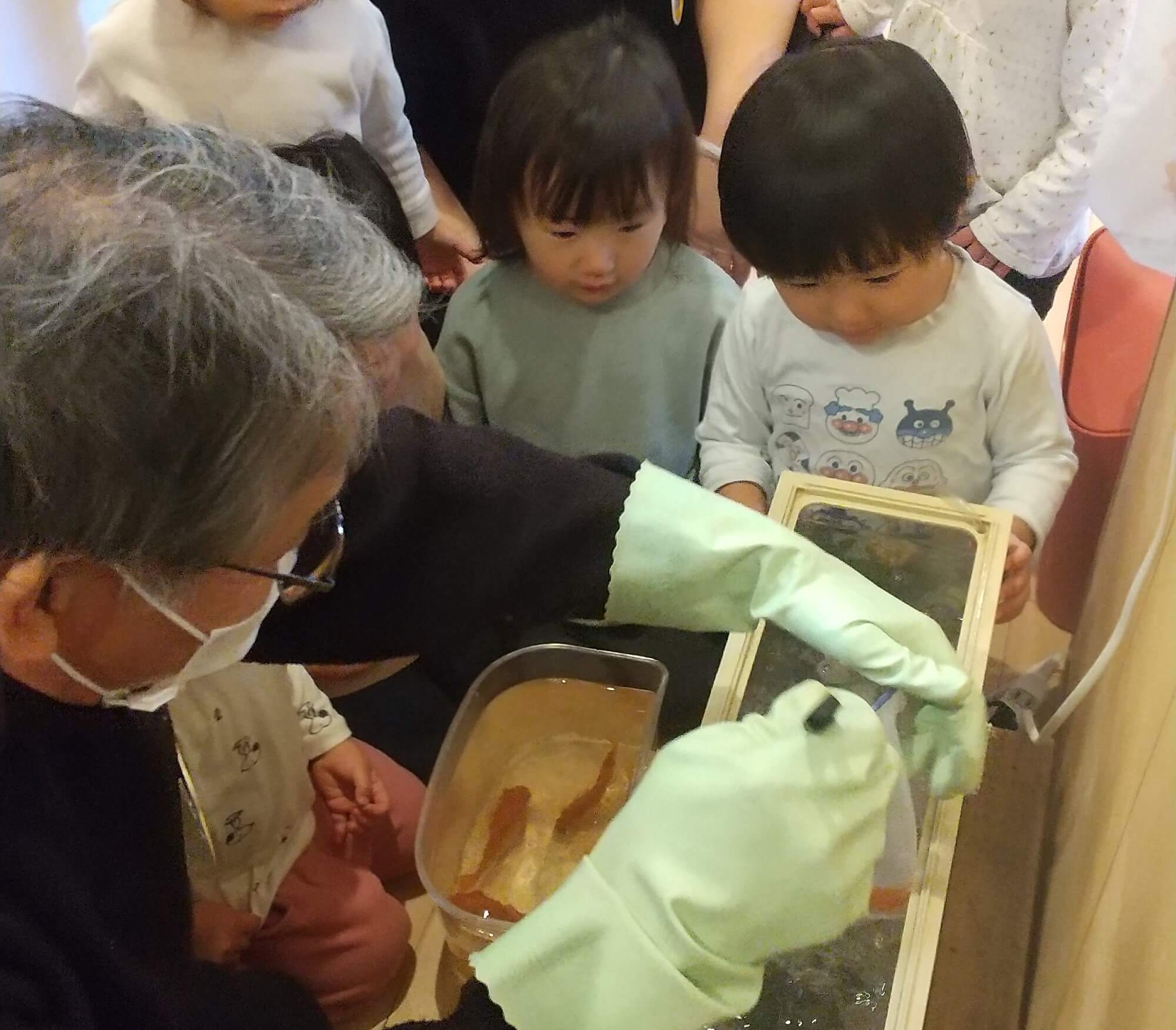 金魚の水槽掃除の手伝いをする子どもたち