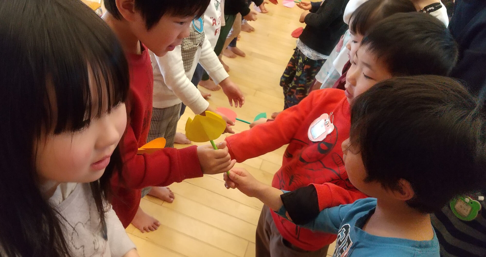 手作りの花のプレゼントを受け取る子どもたち