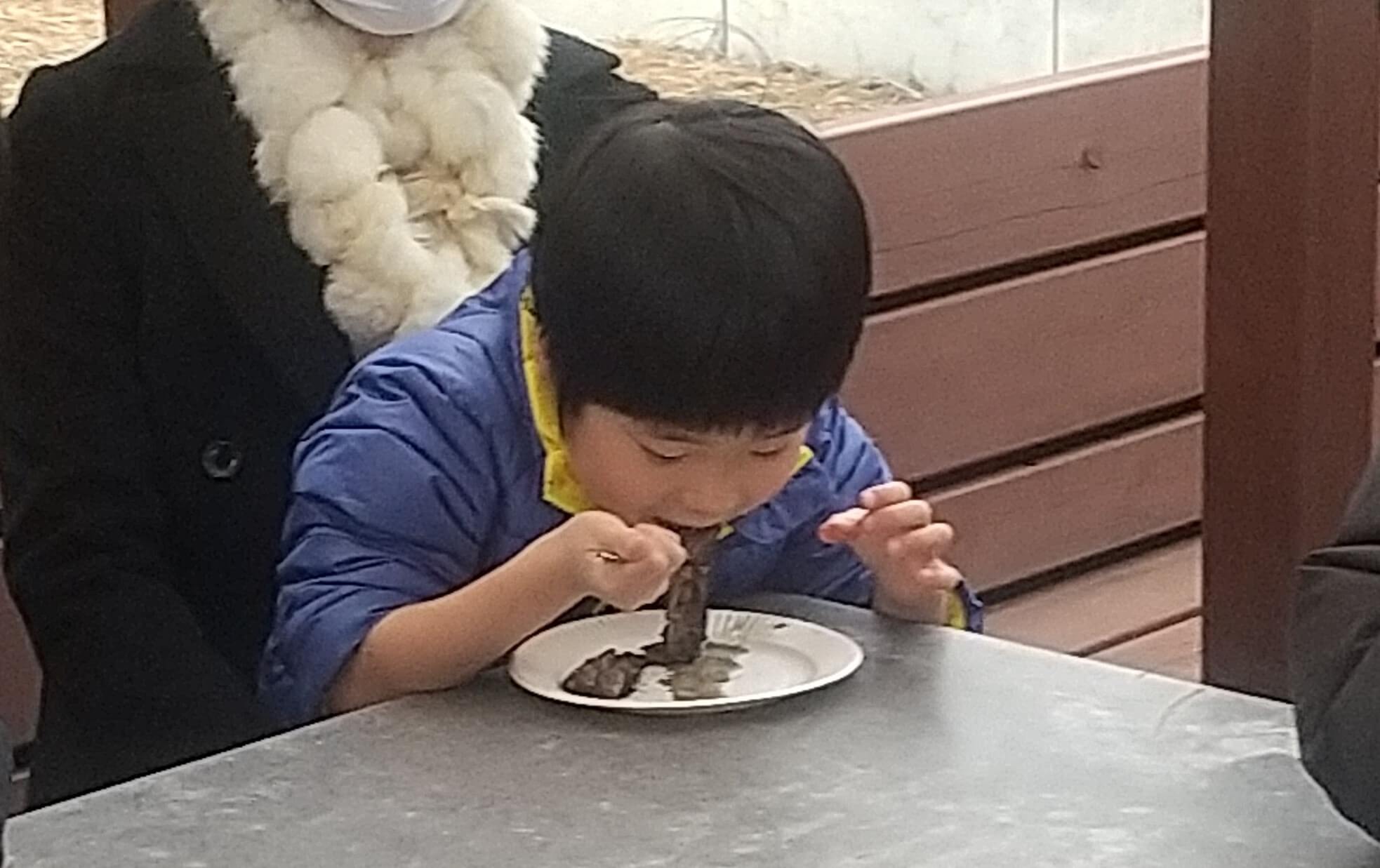 焼いたイワシを食べる子ども