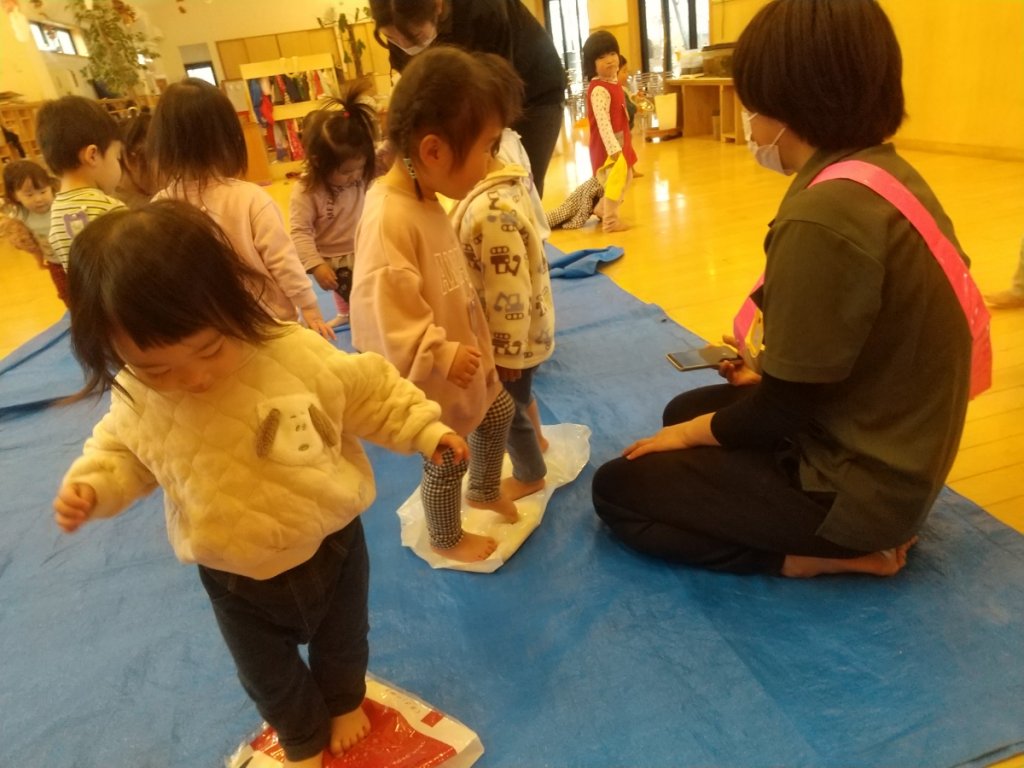 うどん生地を足で踏む子どもたち