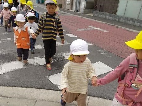 子ども同士で手をつないで散歩する様子