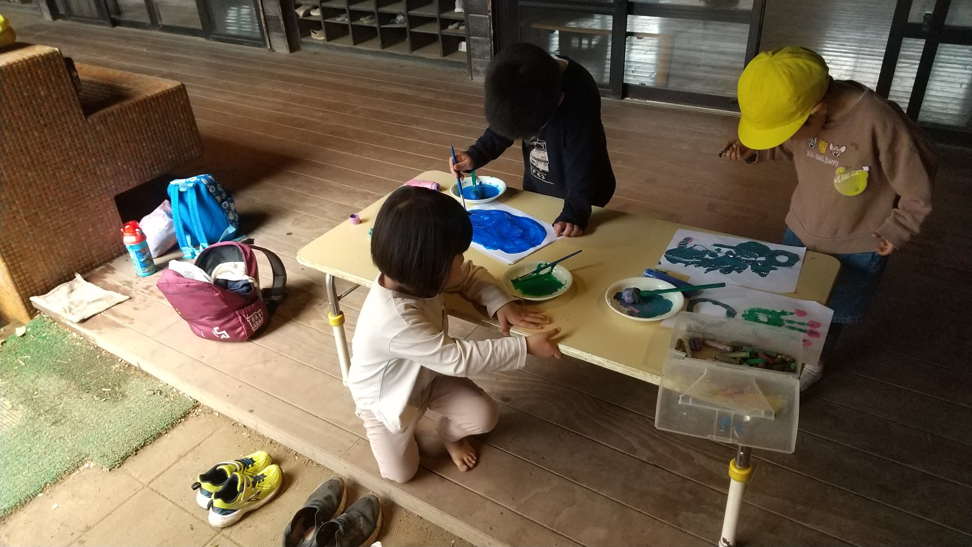 縁側で絵具遊びをする子どもたち