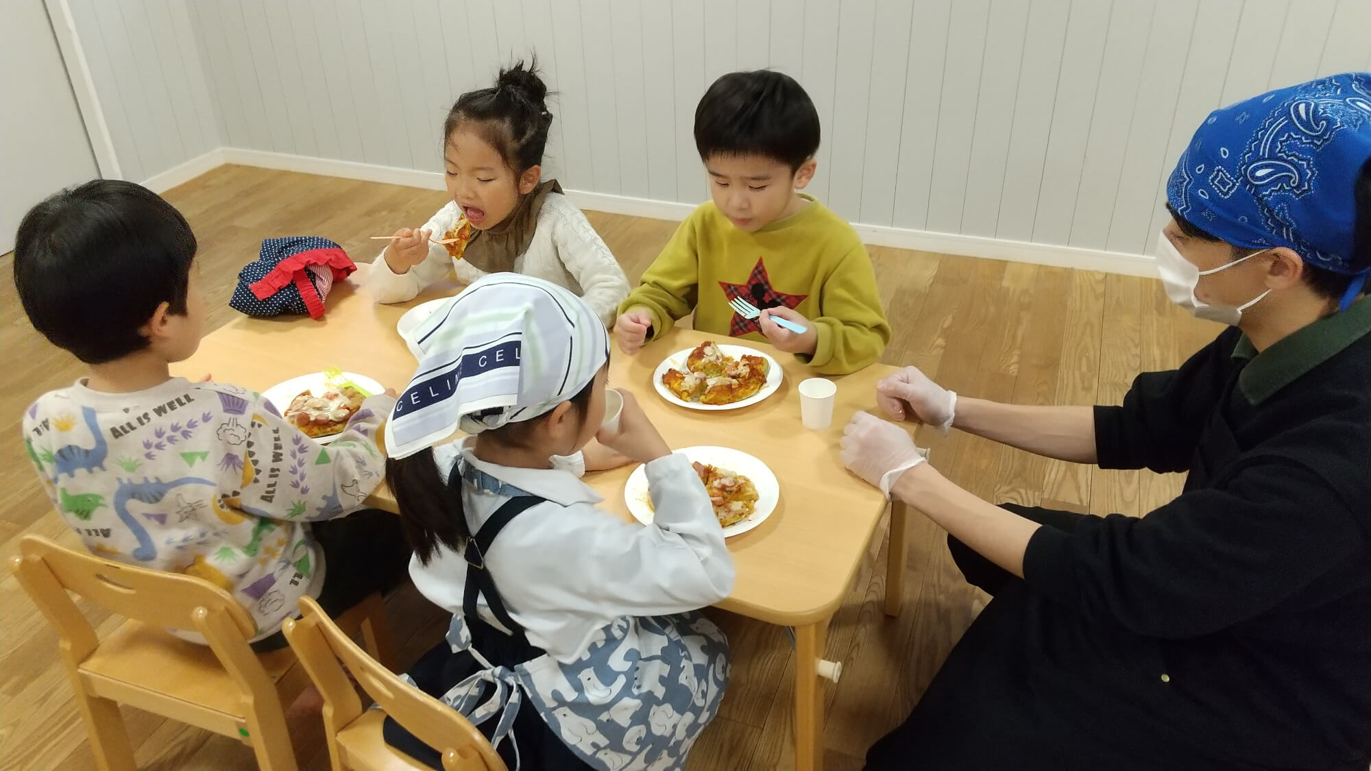 手作りのほうれん草ピザを食べる子どもたち