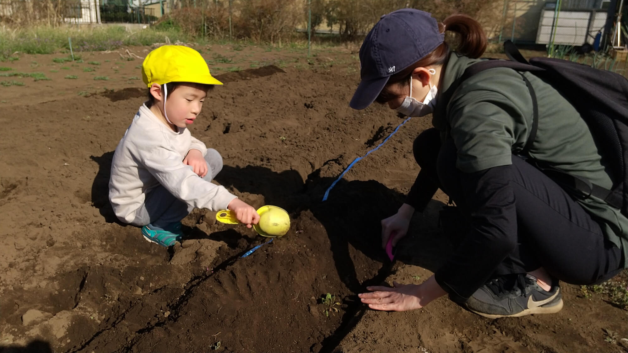 紐に沿って畝を作る子ども