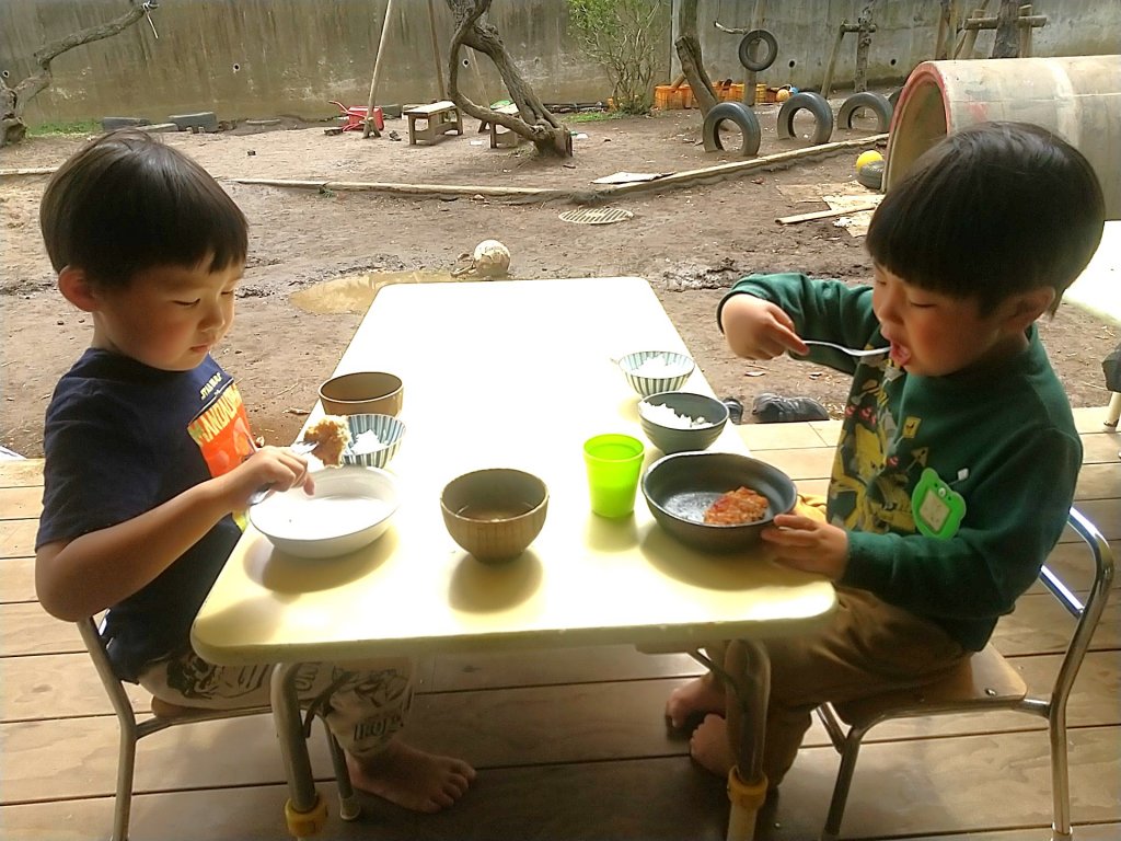 縁側で給食を食べる子どもたち