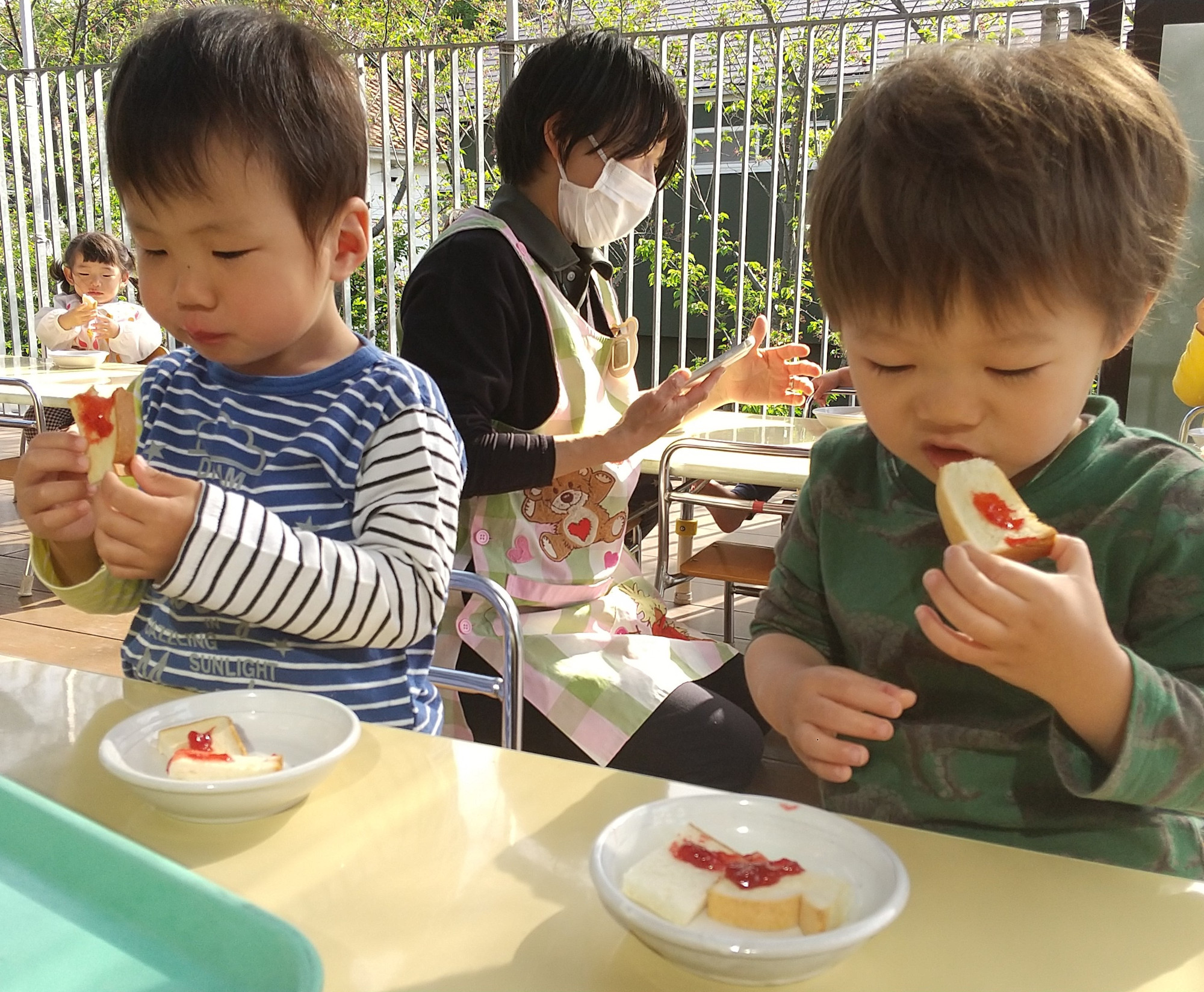 作ったジャムをトーストに乗せて食べる子どもたち