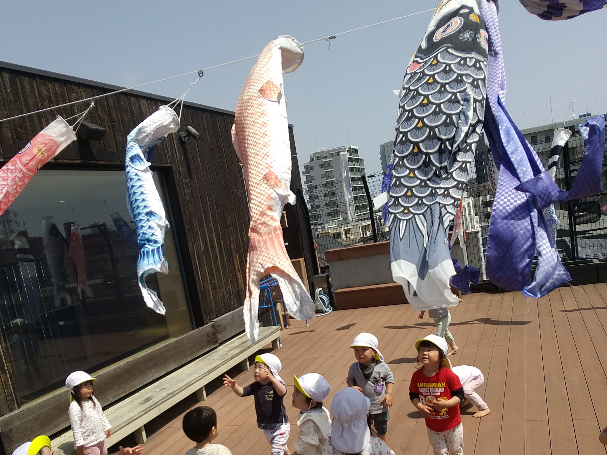 屋上で鯉のぼりを眺める子どもたち