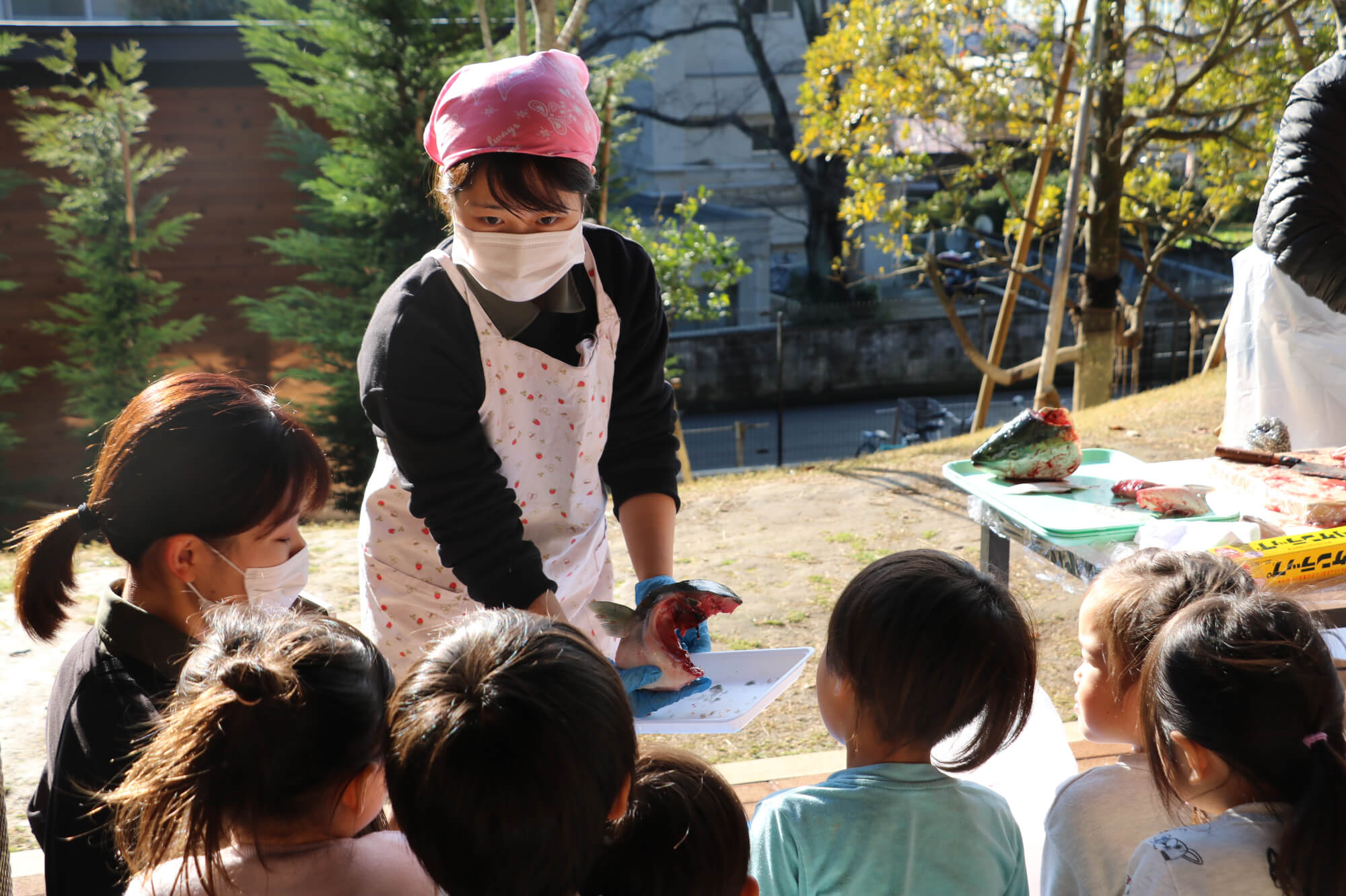 子どもたちに解体した部位を見せて説明する戸邉さん