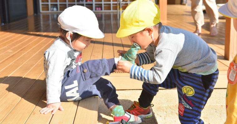 年下児の準備を手助けする子ども