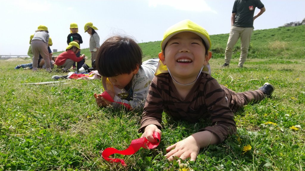 土手に寝転ぶ子どもたち